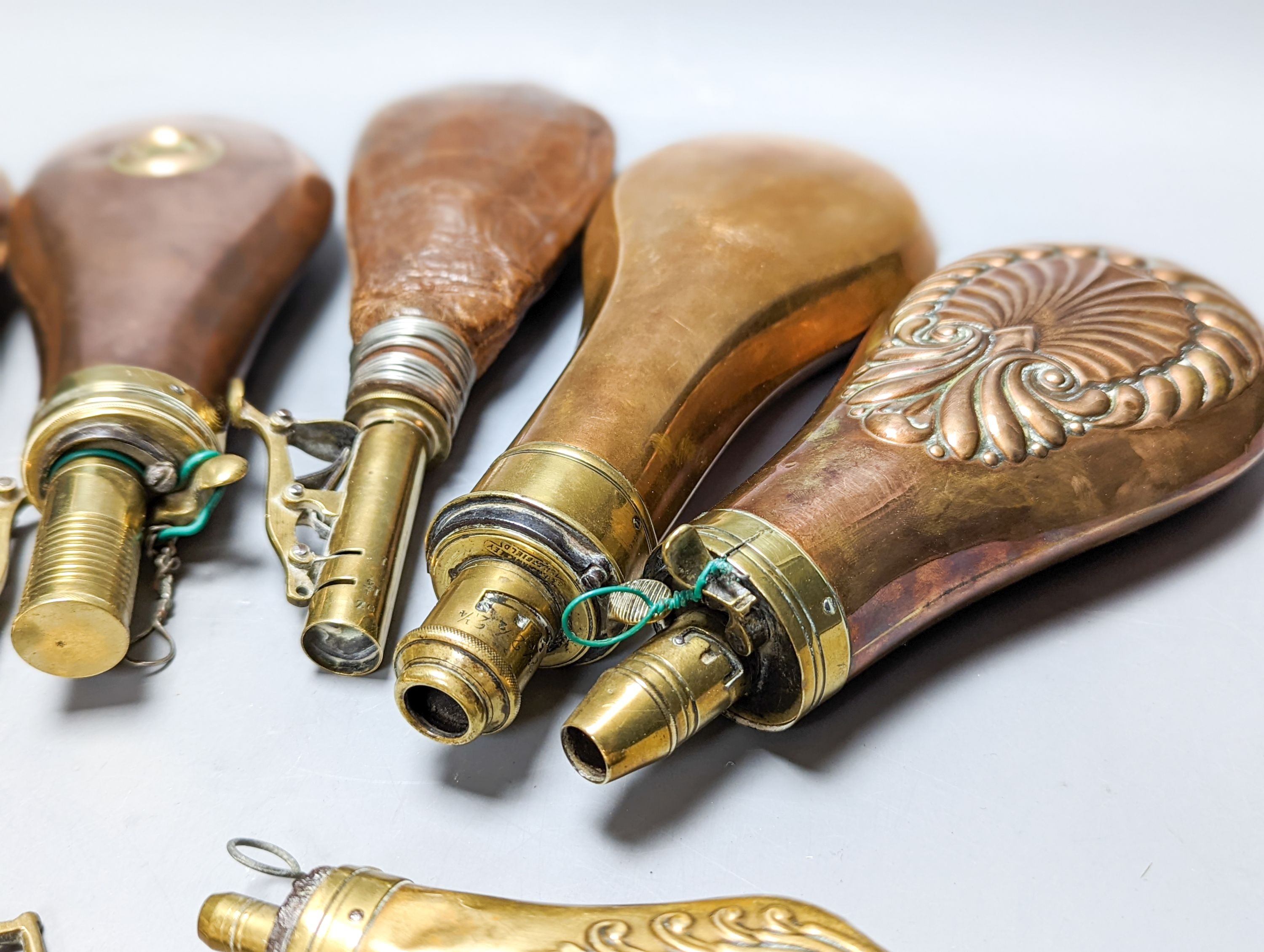 Six powder/shot flasks, 4 copper and brass, 2 leather and brass, together with a carved powder horn (7)